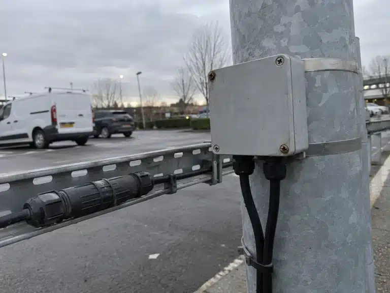 IP68 junction box fitted to a light pole next to a mated waterproof connector, showing two different ways to close an outdoor joint