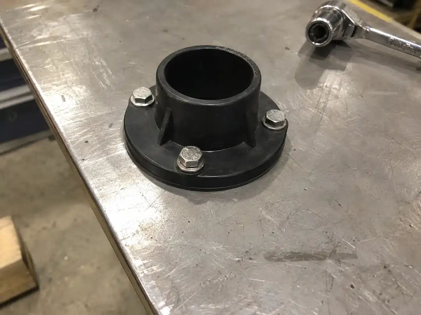 Dry-fitting a waterproof bulkhead connector into a control cabinet wall.